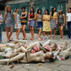 A group of women stare at broken models and a topless man, by Liu Jing.